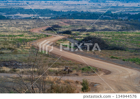Winding Dirt Road Through Vast Open Landscape Winding Dirt Road Through Vast Open Landscape 134944576
