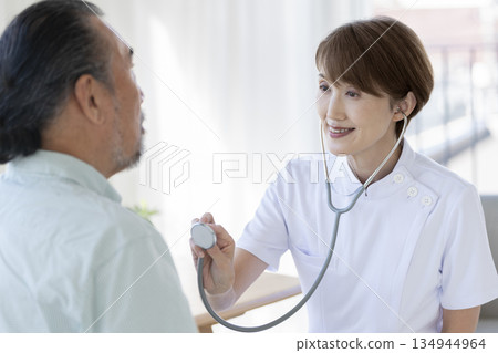 一位資深女醫師正在為一位老年男性做檢查 134944964