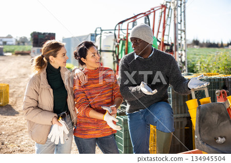 Positive multiracial group of farmers talking in farm backyard Positive multiracial group of farmers talking in farm backyard 134945504