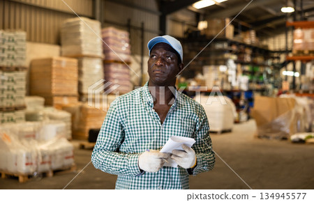 Positive African American man worker posing at warehouse 134945577