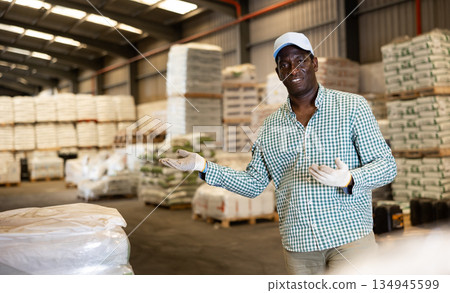 Positive African American man worker posing at warehouse 134945599