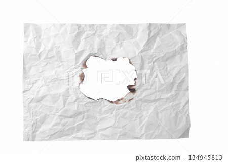 A roughly torn hole in a piece of crumpled white paper, revealing the background. A versatile design element symbolizing emptiness or revelation. On a transparent background. 134945813