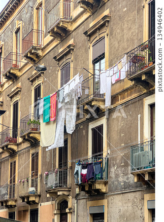 Drying laundry hanging on balconies of old building in catania 134946402