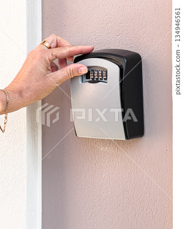 Hand inputting code on key lockbox for access Hand inputting code on key lockbox for access 134946561