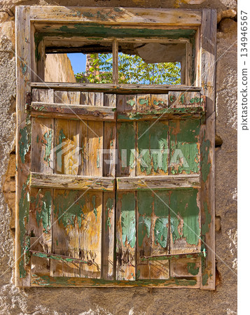 Abandoned old wooden window with peeling green paint 134946567