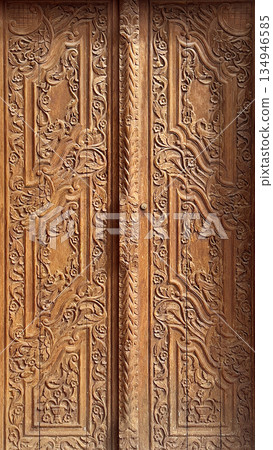 Carved wooden door showing intricate floral patterns and classic ornament Carved wooden door showing intricate floral patterns and classic ornament 134946585