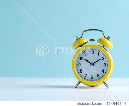 Minimalist decor. Yellow metal alarm clock with yellow bells on pastel blue background. Minimalist decor. Yellow metal alarm clock with yellow bells on pastel blue background. 134946844