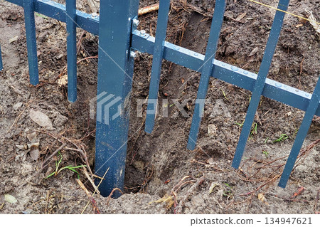 Fence installation. Digging a hole for metal fence posts. Fence installation. Digging a hole for metal fence posts. 134947621