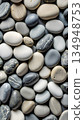 Close-up of river stone texture with smooth gray pebbles and water-worn surface - natural rock pattern filling the frame 134948753