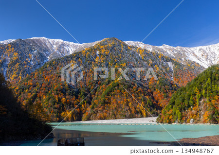 長野縣大町市平良-高瀨水壩調節湖的秋葉呈現出鮮豔的乳藍色,遠處是白雪皚皚的山峰,映襯著蔚藍的天空。 長野縣大町市平良-高瀨水壩調節湖的秋葉呈現出鮮豔的乳藍色,遠處是白雪皚皚的山峰,映襯著蔚藍的天空。 134948767