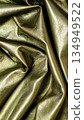 Luxurious golden metallic leather texture with elegant folds and wrinkles creating premium material surface 134949522