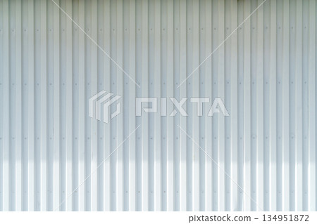 White corrugated metal wall background texture with vertical lines and rivets. Clean industrial surface for construction or architectural backdrop. Frontal view with bright natural light. White corrugated metal wall background texture with vertical lines and rivets. Clean industrial surface for construction or architectural backdrop. Frontal view with bright natural light. 134951872