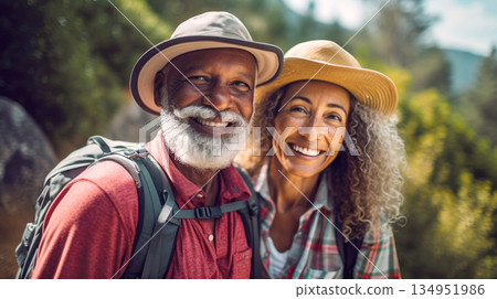 Middle aged couple walking on forest path with backpacks in summer 134951986