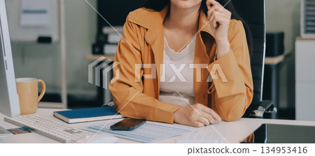 Business woman using calculator for do math finance on wooden desk in office and business working background, tax, accounting, statistics and analytic research concept. 134953416