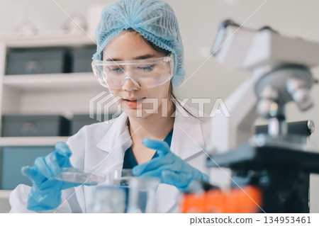 Portrait, science and happy woman on laptop in lab to research chemistry, test or innovation. Microscope, scientist and face of medical doctor in goggles for microbiology, healthcare or pharma study 134953461