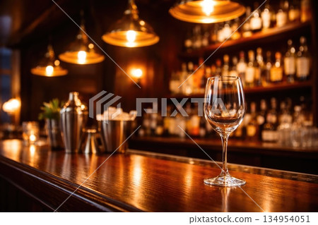 Elegant Empty Wine Glass on Wooden Bar Counter with Warm Ambient Lighting Elegant Empty Wine Glass on Wooden Bar Counter with Warm Ambient Lighting 134954051