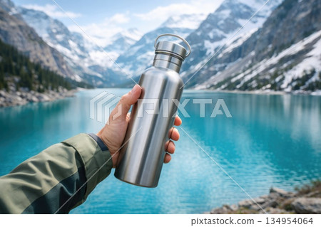 Reusable Stainless Steel Water Bottle Held at Mountain Lake 134954064
