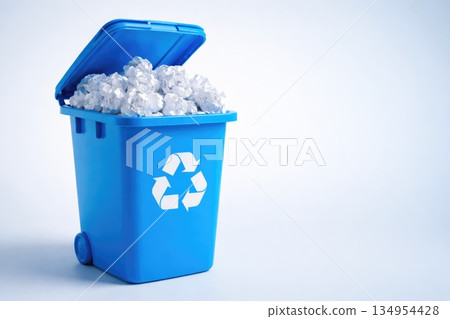 Blue Recycling Bin Full of Paper Waste on White Background Blue Recycling Bin Full of Paper Waste on White Background 134954428