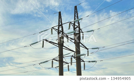 Electricity pylons rising against a backdrop of a cloudy sky in crimea, ukraine, supporting essential power lines for energy distribution Electricity pylons rising against a backdrop of a cloudy sky in crimea, ukraine, supporting essential power lines for energy distribution 134954905