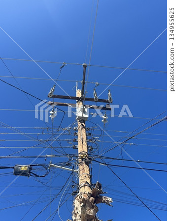 Electric poles and wires stretching into the sky 134955625