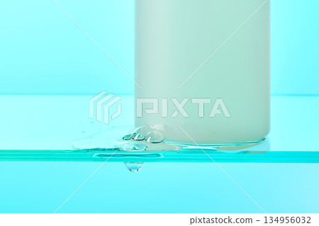 Skincare product bottle promoting hydration on blue background Skincare product bottle promoting hydration on blue background 134956032