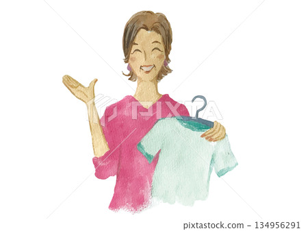 一位面帶微笑、衣著時尚的高級女店員，手裡拿著掛在衣架上的衣服。 134956291