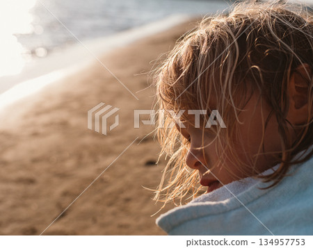 Child with Wet Hair Relaxing on the Beach in the Sun Child with Wet Hair Relaxing on the Beach in the Sun 134957753