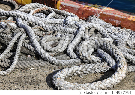 Mooring line on rusty pier bollard referred to a post on a ship or quay. Mooring line on rusty pier bollard referred to a post on a ship or quay. 134957791