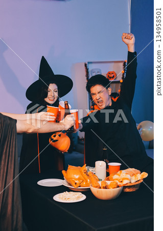 Friends enjoying a Halloween party at a bar making a toast 134958501