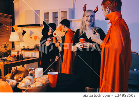 Friends enjoying a Halloween party at a bar making a toast 134958502