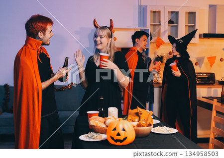 Friends enjoying a Halloween party at a bar making a toast 134958503