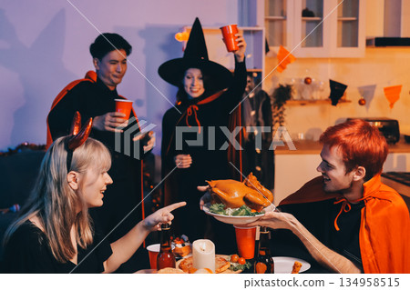 Friends enjoying a Halloween party at a bar making a toast 134958515