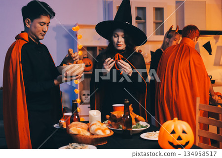 Friends enjoying a Halloween party at a bar making a toast 134958517