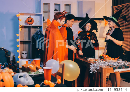 Friends enjoying a Halloween party at a bar making a toast Friends enjoying a Halloween party at a bar making a toast 134958544