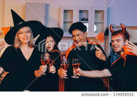 Friends enjoying a Halloween party at a bar making a toast 134958552