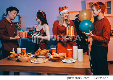 Festive Office Christmas Party with Delicious Food. A beautifully decorated office space with Christmas trees and festive lights, set up for a holiday party. 134958560