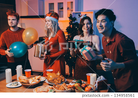 Festive Office Christmas Party with Delicious Food. A beautifully decorated office space with Christmas trees and festive lights, set up for a holiday party. 134958561