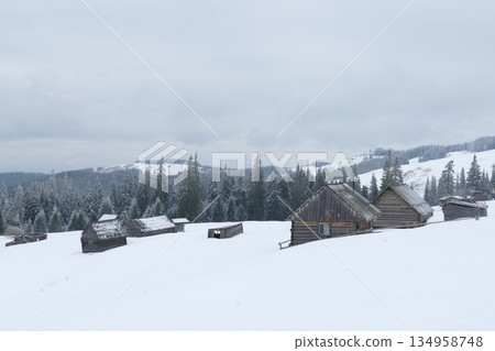 Old wooden houses in Carpathian village. Cold weather in mountain village Old wooden houses in Carpathian village. Cold weather in mountain village 134958748