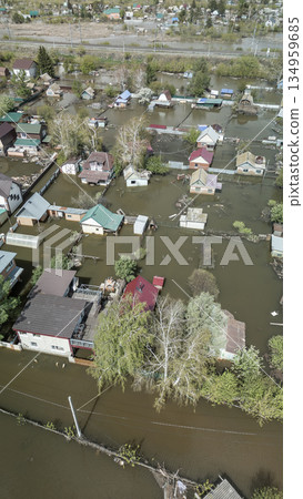 Aerial drone footage of a massive city flood with houses and streets submerged under water. Urban flooding caused by extreme weather and heavy rainfall, showing natural disaster impact on residential  134959685