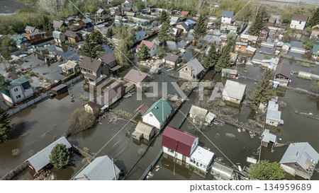 Aerial drone footage of a massive city flood with houses and streets submerged under water. Urban flooding caused by extreme weather and heavy rainfall, showing natural disaster impact on residential  134959689