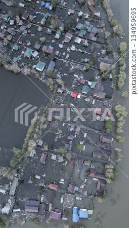 Aerial drone footage of a massive city flood with houses and streets submerged under water. Urban flooding caused by extreme weather and heavy rainfall, showing natural disaster impact on residential  134959695