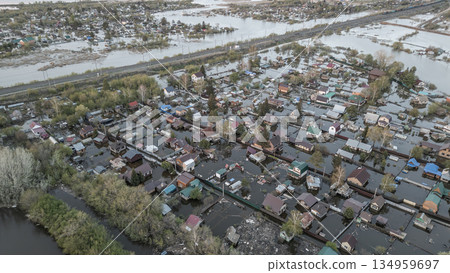 Aerial drone footage of a massive city flood with houses and streets submerged under water. Urban flooding caused by extreme weather and heavy rainfall, showing natural disaster impact on residential  134959697