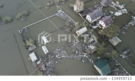 Aerial drone footage of a massive city flood with houses and streets submerged under water. Urban flooding caused by extreme weather and heavy rainfall, showing natural disaster impact on residential  134959713