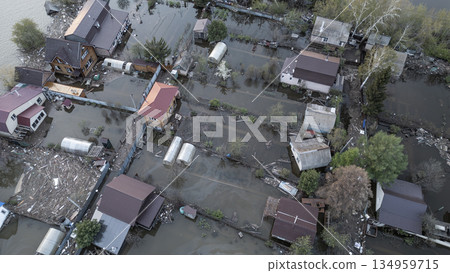 Aerial drone footage of a massive city flood with houses and streets submerged under water. Urban flooding caused by extreme weather and heavy rainfall, showing natural disaster impact on residential Aerial drone footage of a massive city flood with houses and streets submerged under water. Urban flooding caused by extreme weather and heavy rainfall, showing natural disaster impact on residential 134959715