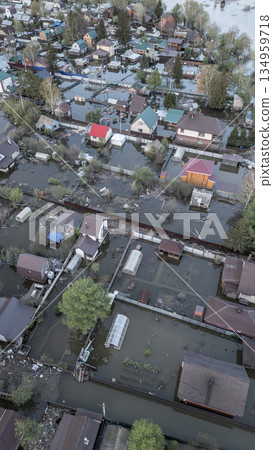 Aerial drone footage of a massive city flood with houses and streets submerged under water. Urban flooding caused by extreme weather and heavy rainfall, showing natural disaster impact on residential  134959718