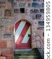 Arched Stone Doorway With Red And White Striped Door And Weathered Steps Old Building Entrance 134959805