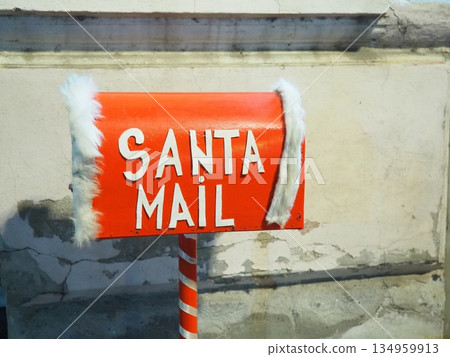 Closeup on Christmas decorated mailbox for letters to Santa Claus. Design of festive xmas letterbox. A post box. Mailbox Christmas. Red mail outdoors for send children wishes at New Year holiday. 134959913