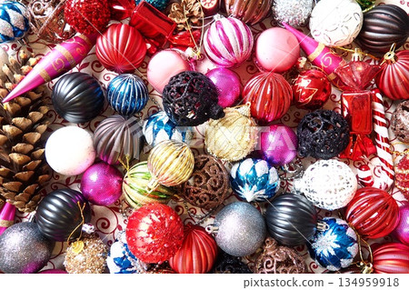 Brightly colored ornaments scatter across a surface, reflecting the spirit of Christmas and New Year. Various shapes and sizes add to the holiday charm, inviting moments of joy and celebration Brightly colored ornaments scatter across a surface, reflecting the spirit of Christmas and New Year. Various shapes and sizes add to the holiday charm, inviting moments of joy and celebration 134959918