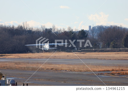 A small propeller passenger plane runs to the end of the runway and takes off 134961215