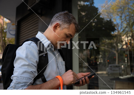 Man using smartphone on city street Man using smartphone on city street 134961545